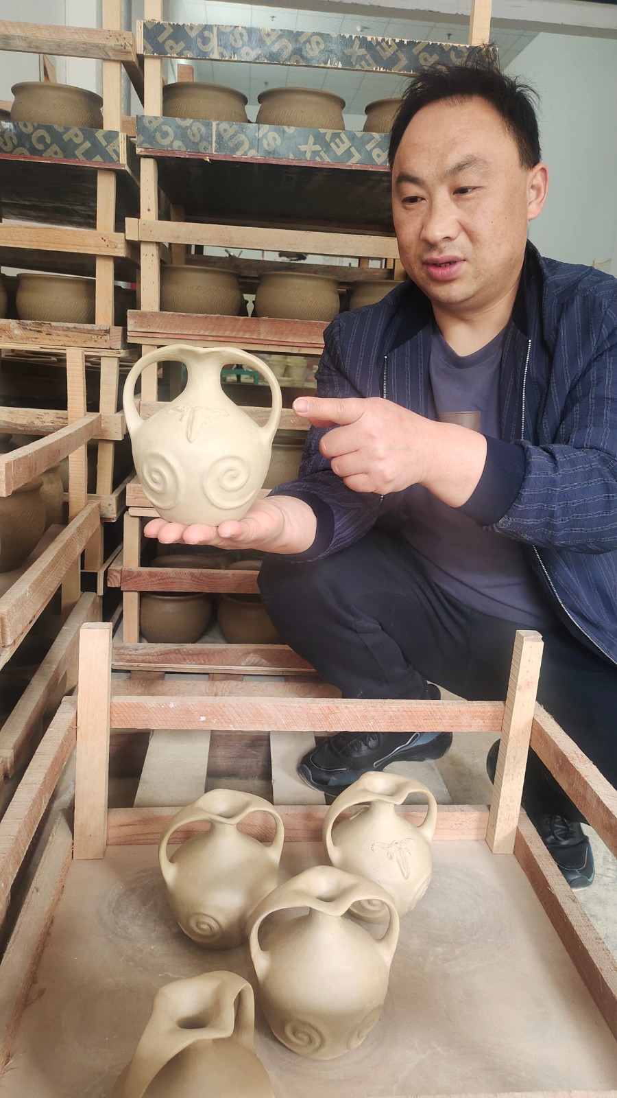彭加榮展示自己設(shè)計(jì)制作的羌族酒器。.jpg