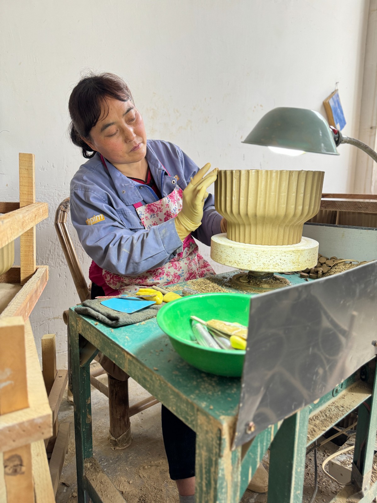 在秦熙禾陶業(yè)有限公司里，女工正在進(jìn)行陶器修胚工序。.jpg